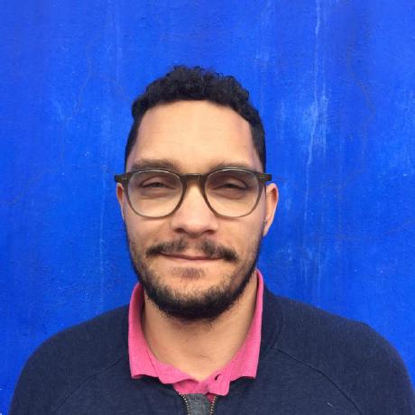 Photo of Kwame Porter Robinson with a blue wall behind him.
